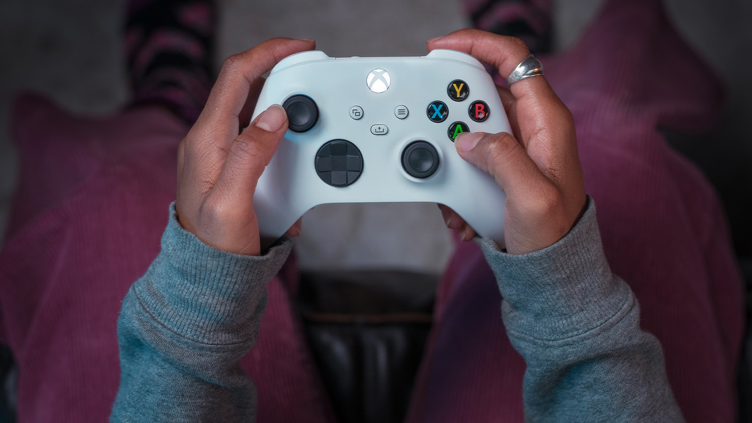 Close-up of a person’s hands holding a white Xbox Wireless Controller